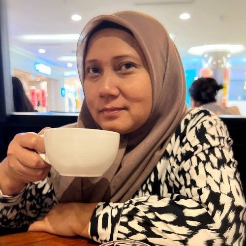 Ibu Yati menyediakan adunan kek buah di dapur